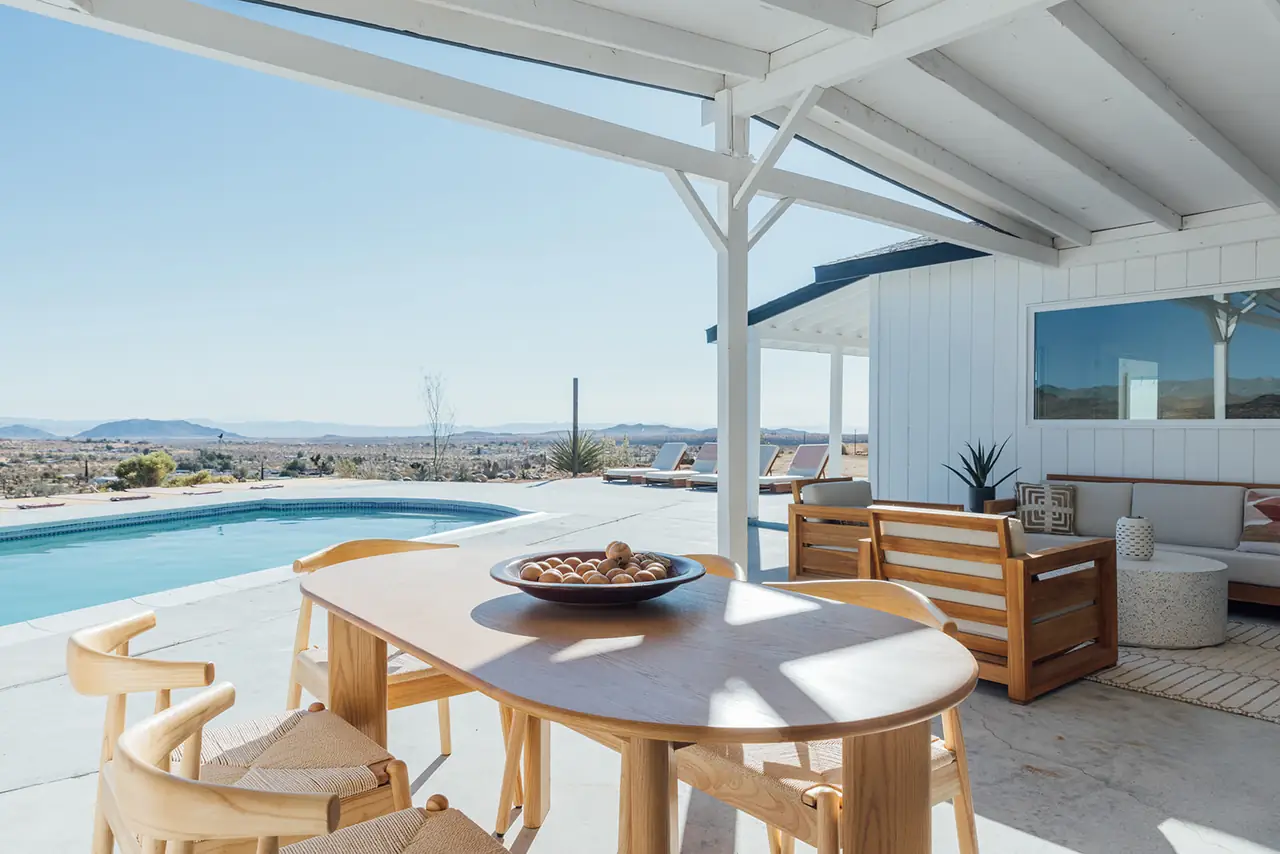 Outdoor dining table beside pool with mountain views