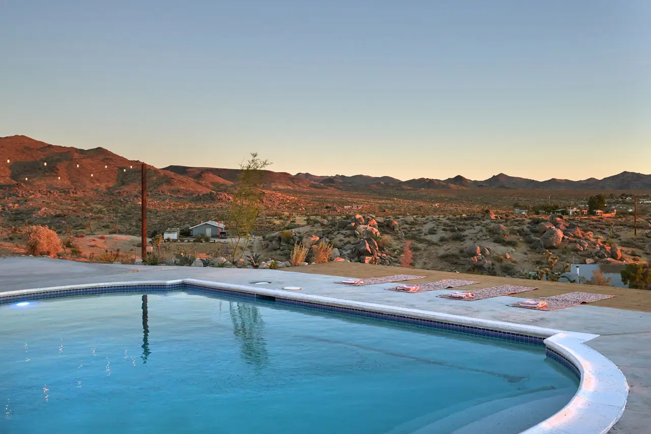 Desert sunset over Joshua Trees and boulders