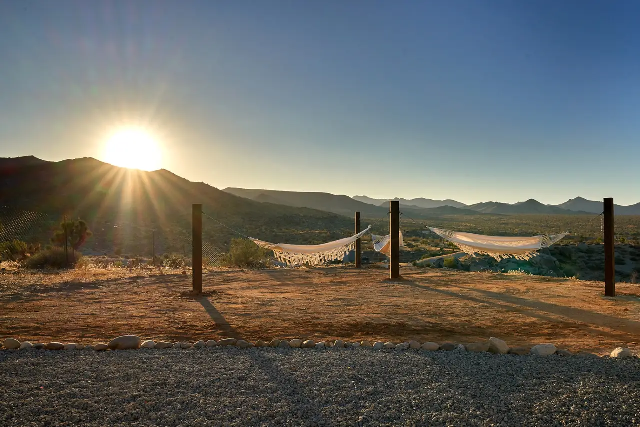 Hammocks strung across desert overlook at sunset